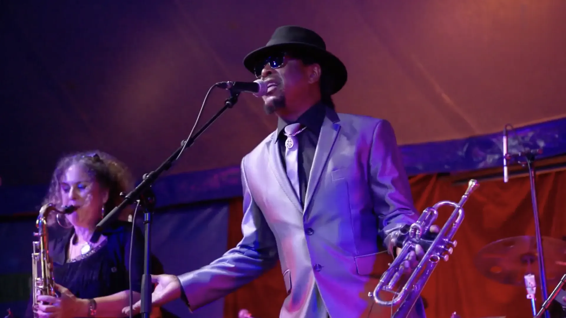 Chanteur et saxophoniste sur scène lors d'un concert du festival Jazz au Phare